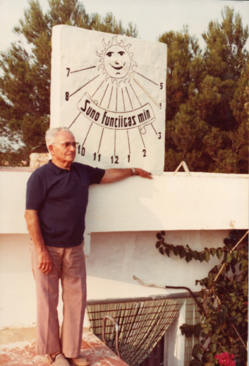 Félix Navarro davant del rellotge de sol que es va construir a la casa d'estiu, amb la divisa «Suno funciigas min» —«el sol em fa funcionar»—.