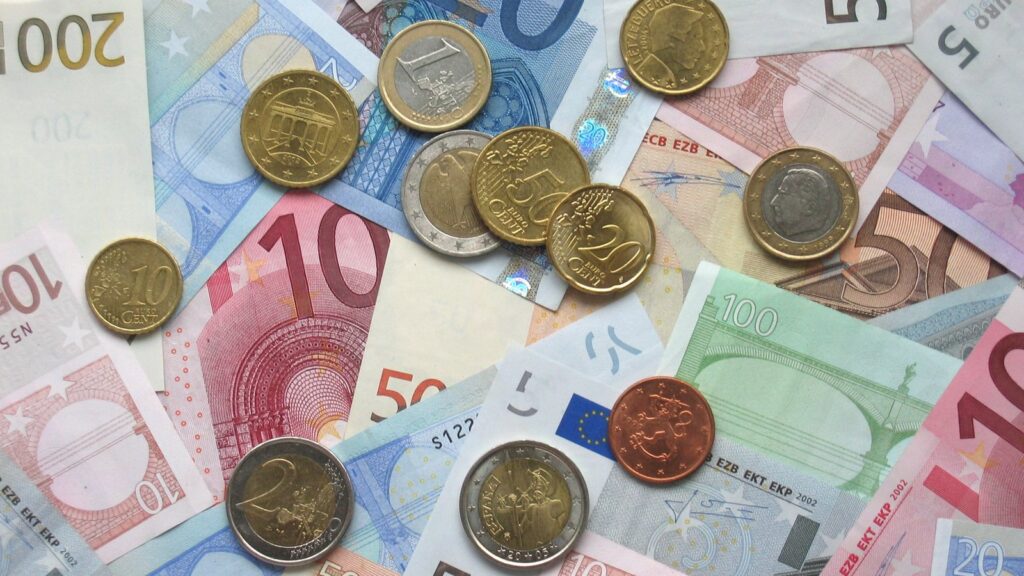 Disĵetitaj eŭroaj moneroj kaj monbiletoj.