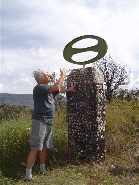 Hilmar Ilton S. Ferreira, autor del símbol jubilar, davant del monument al símbol a la finca-escola Bona Espero, a Alto Paraíso de Goiás (Brasil). Fotografia de Giuseppe Gratapaglia, publicada amb permís del retratat.