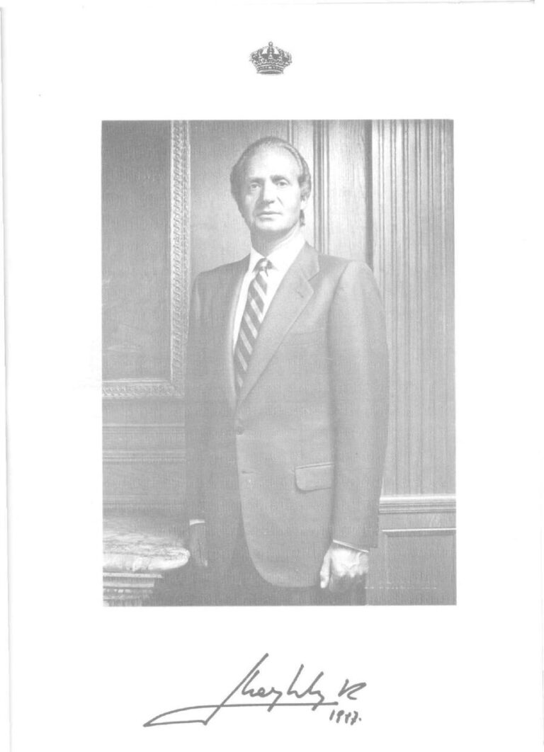 Retrat oficial de Joan Carles I amb la corona reial i la firma facsímil datada en 1987, a pàgina sencera.