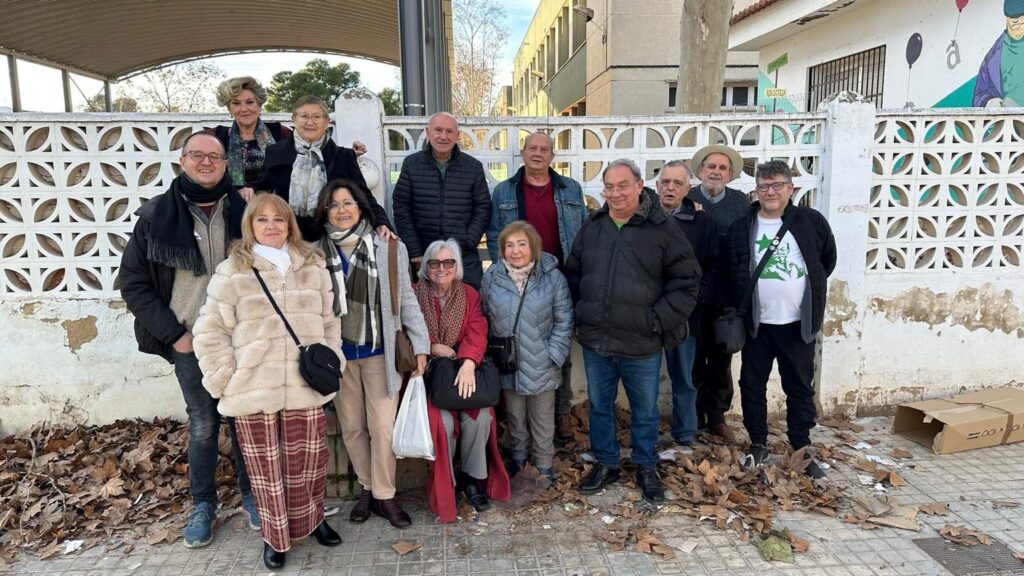 Foto de grupo: una quincena de personas posando en la calle, al aire libre