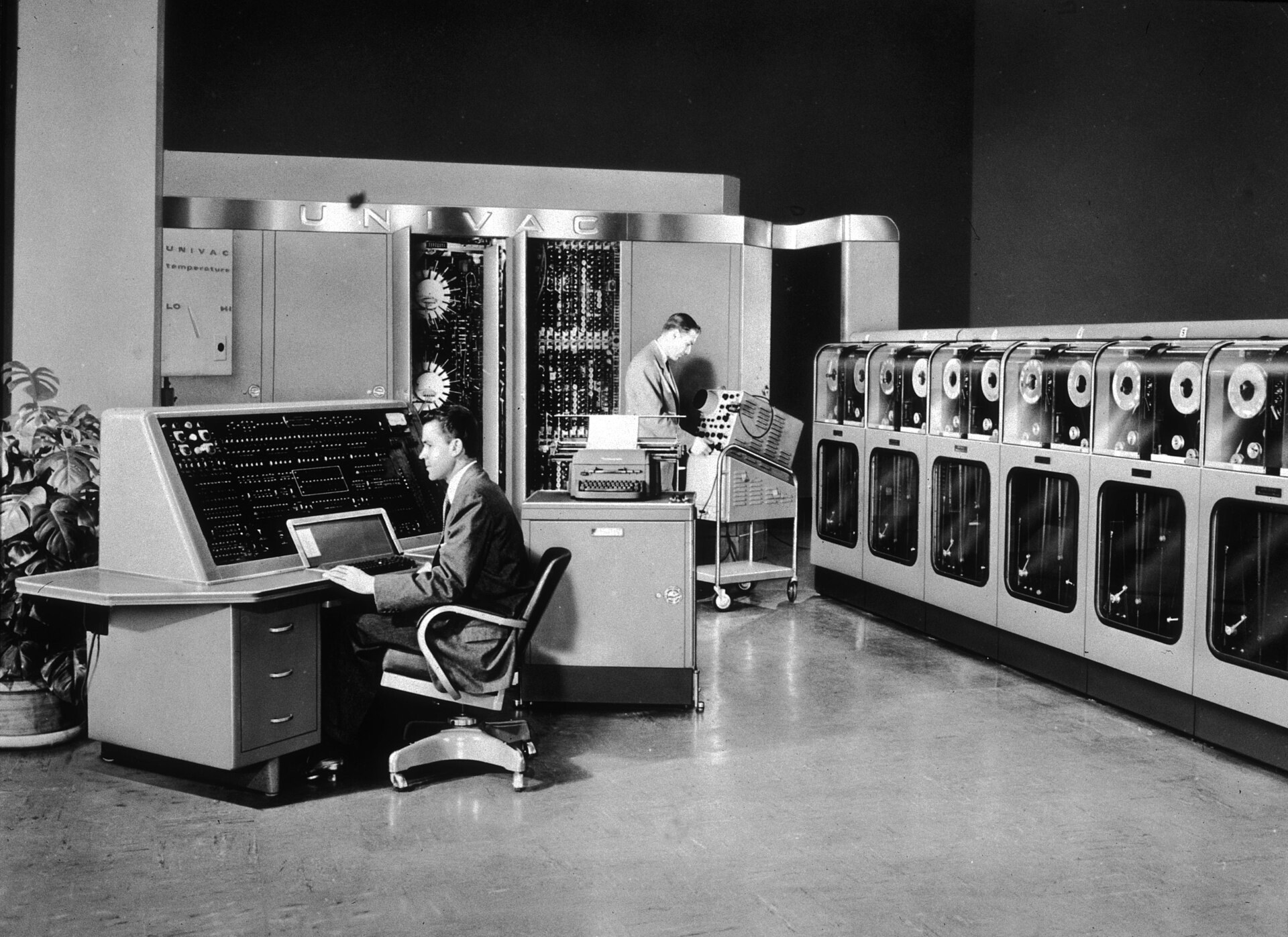 Una sala amb els armaris de l'UNIVAC I, la seua consola i persones treballant.